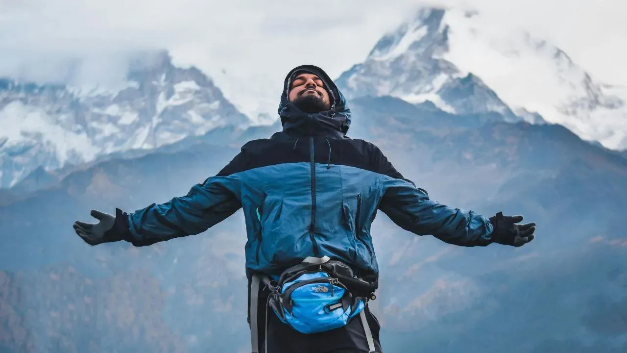 A traveller enjoying peacefully at a snowy hill.